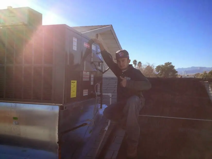 HVAC technician performing Air Duct Repair on a rooftop unit in Crescent City